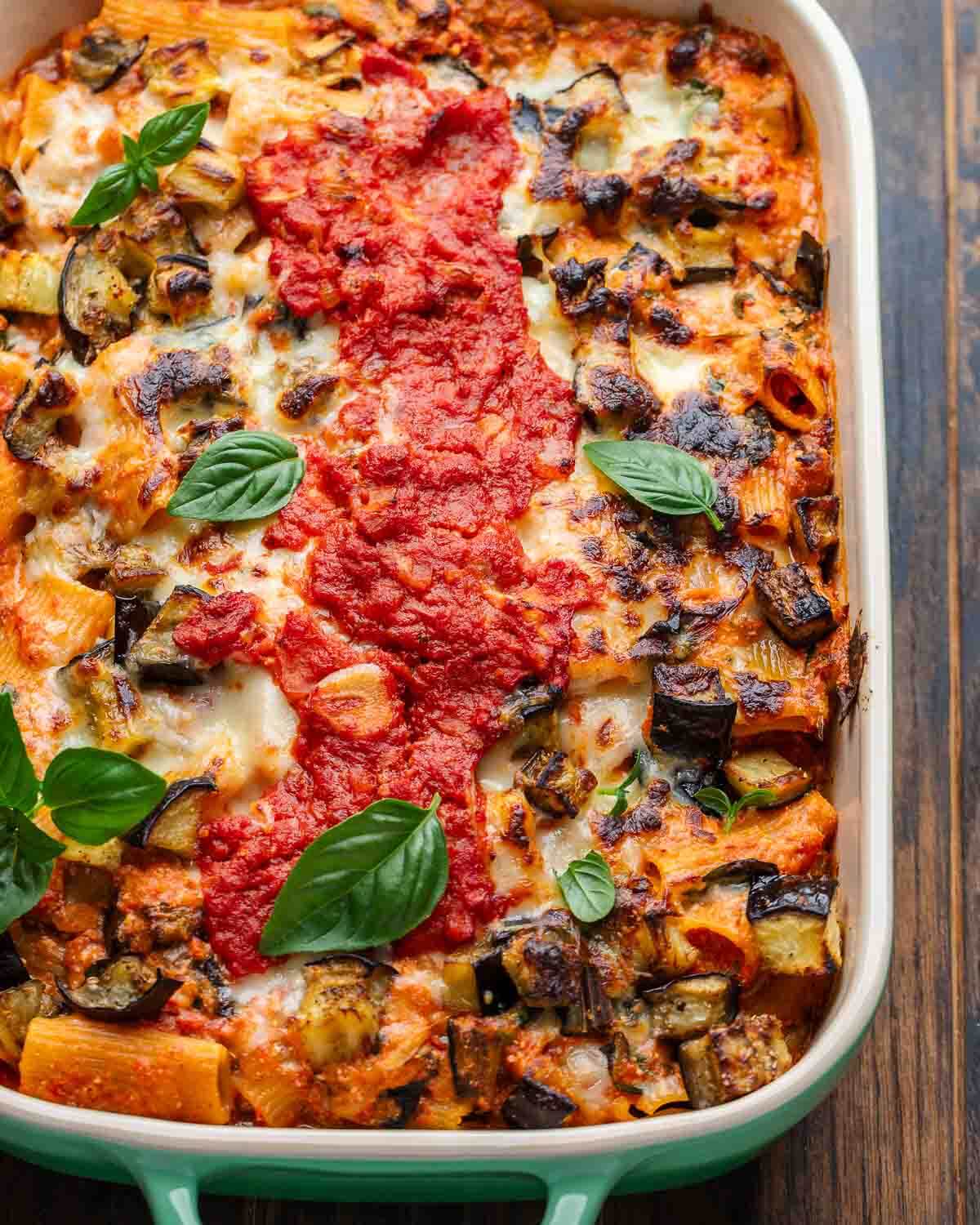 Overhead shot of baked eggplant pasta with basil leaves on top.