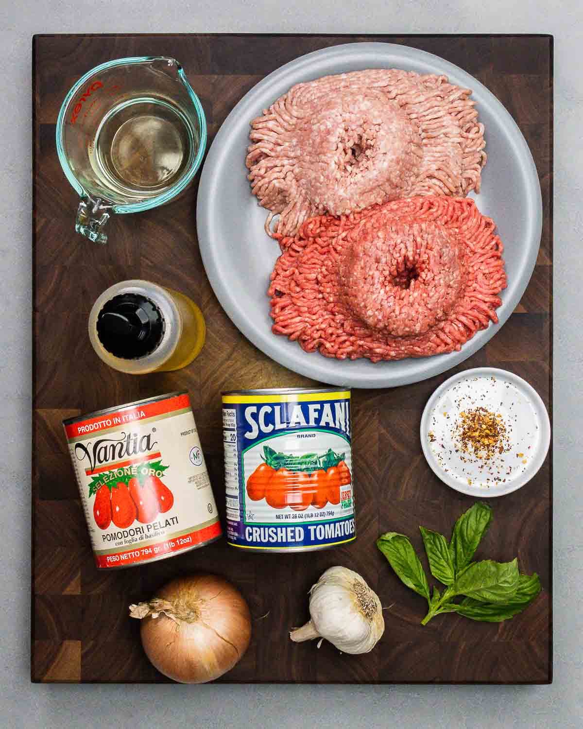 Sauce ingredients shown: white wine, ground chuck and pork, olive oil, canned tomatoes, hot red pepper flakes, onion, garlic, and basil.