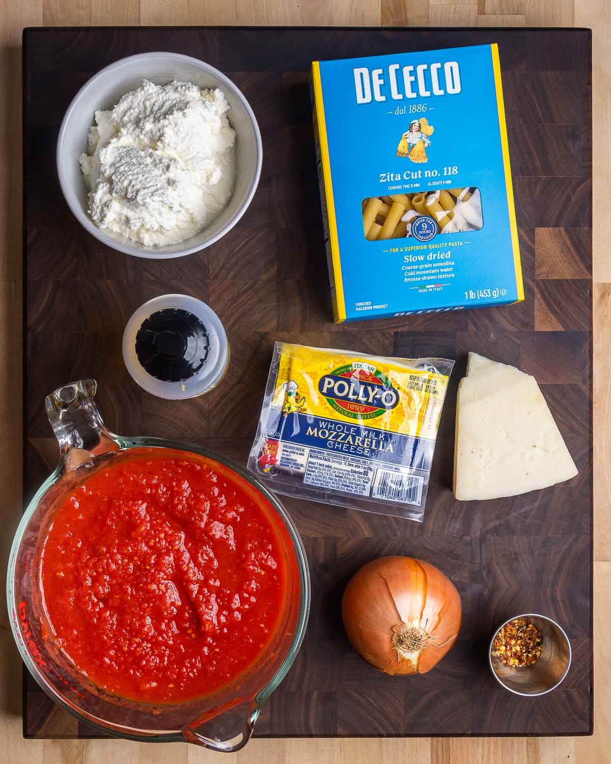 Ingredients shown: ricotta, ziti, olive oil, mozzarella, Pecorino, tomato sauce, onion, and red pepper flakes.