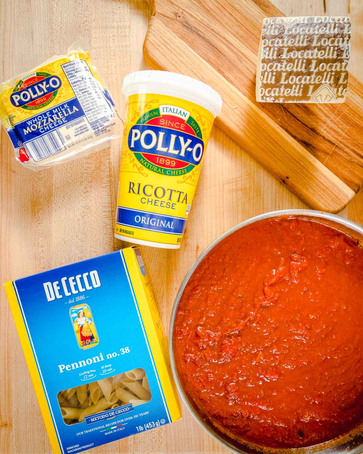 Ingredients shown: Pecorino Romano, mozzarella, ricotta cheese, pasta, and a pot of sauce.