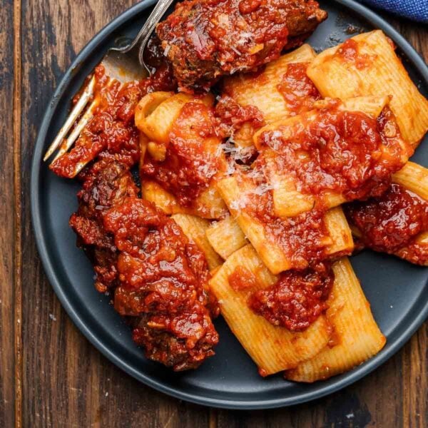 Beef braciole in grey plate with pasta for featured image.