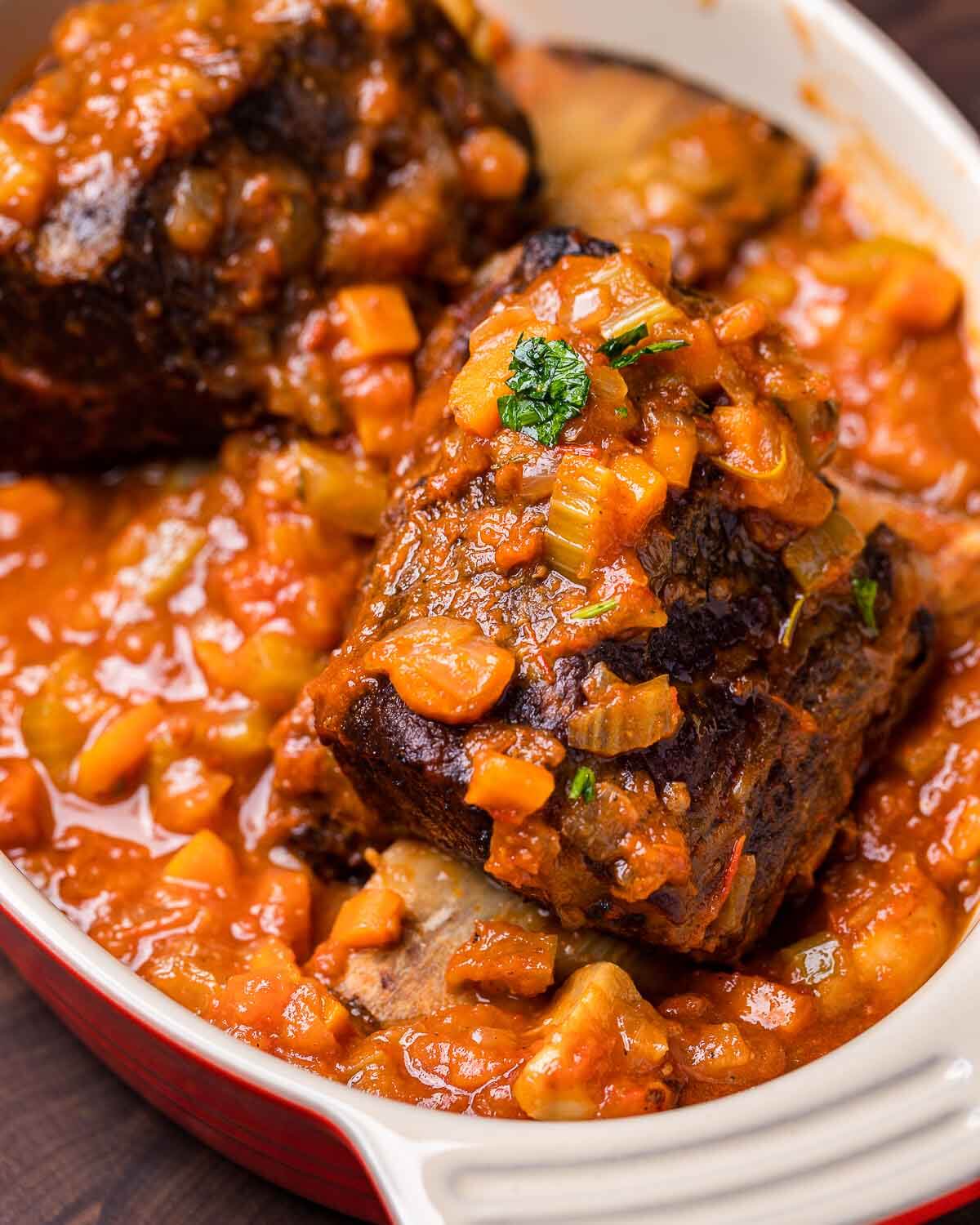 Two brasied short ribs in baking dish.