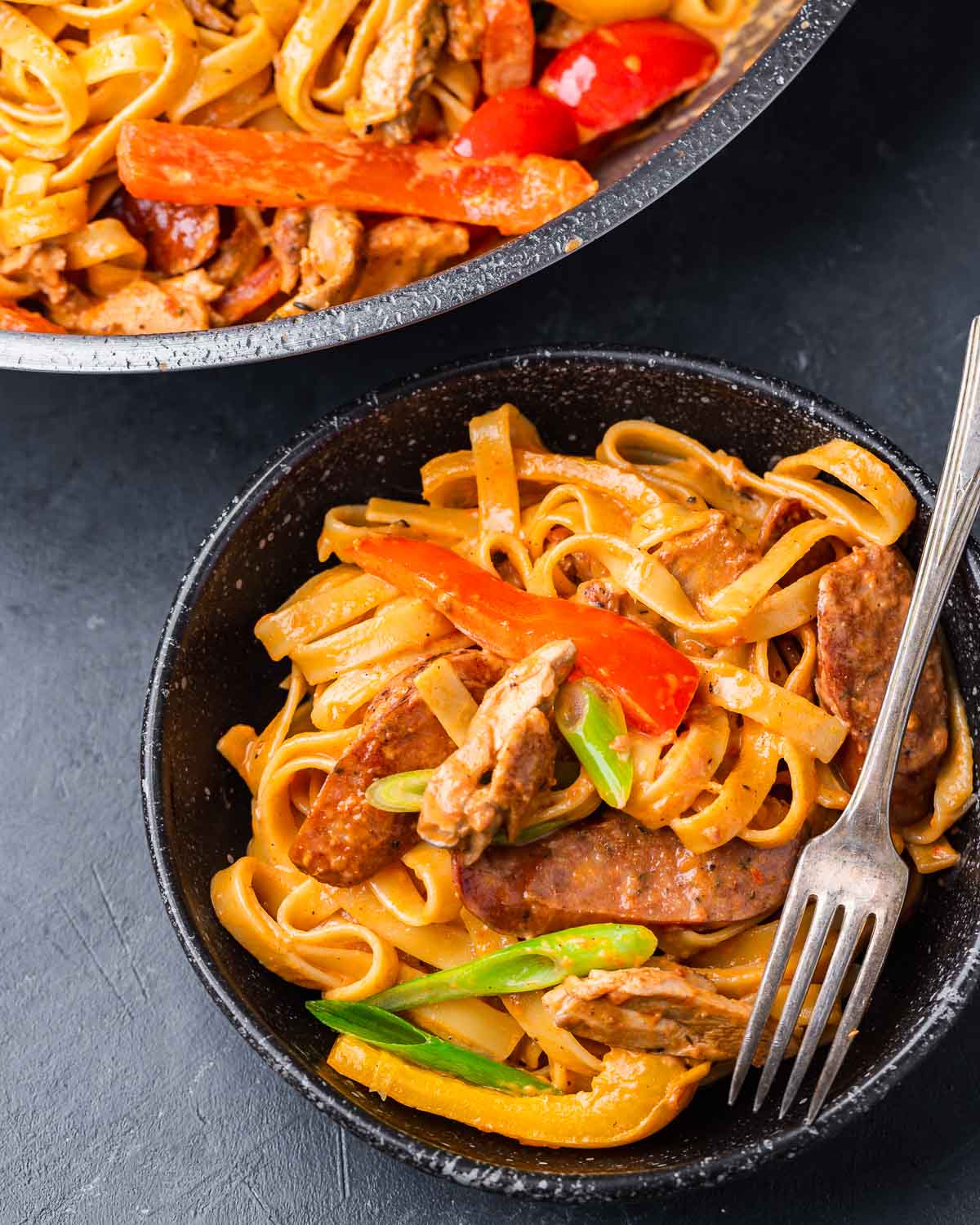 Black bowl with Cajun chicken pasta.