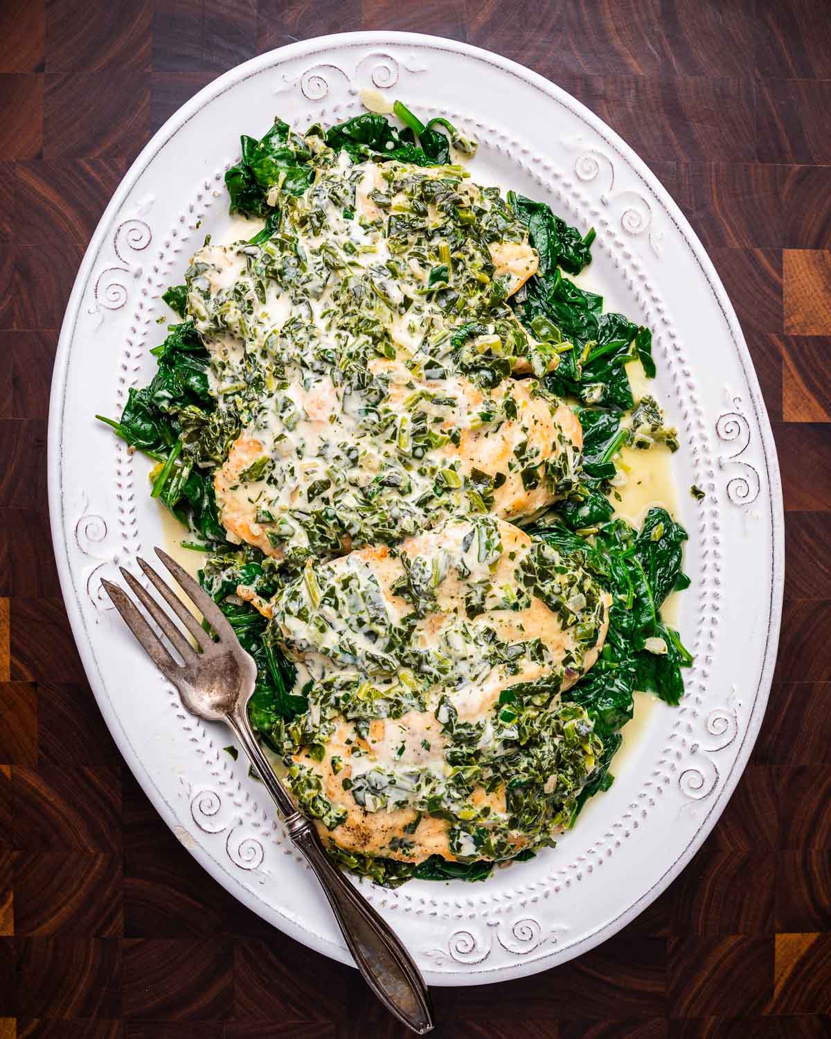 Chicken Florentine in platter on walnut cutting board.