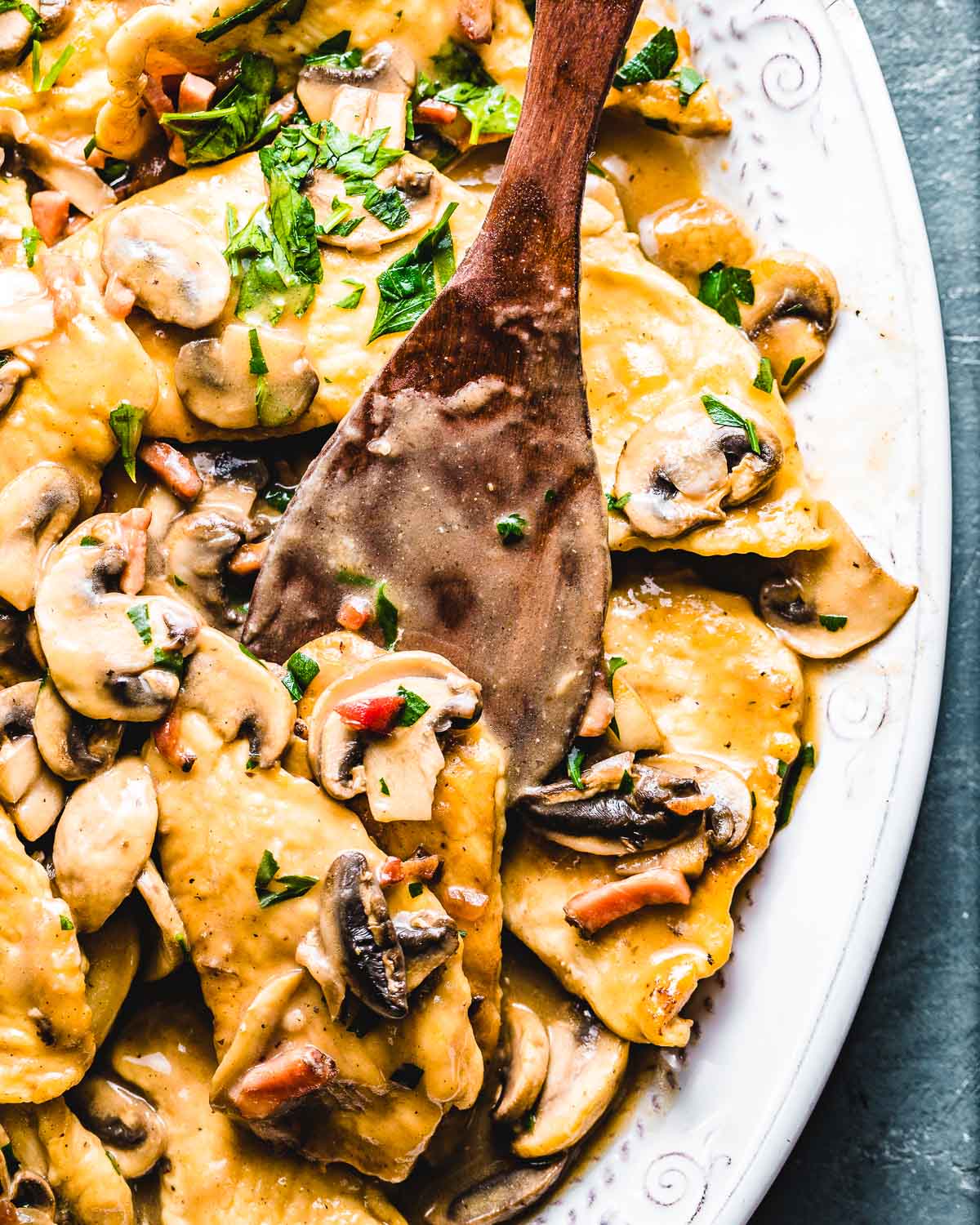 Close up shot of chicken marsala on blue background.