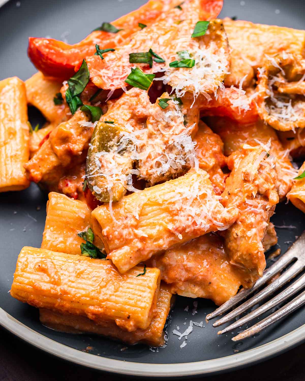 Rigatoni with cherry pepper cream sauce in blue plate.