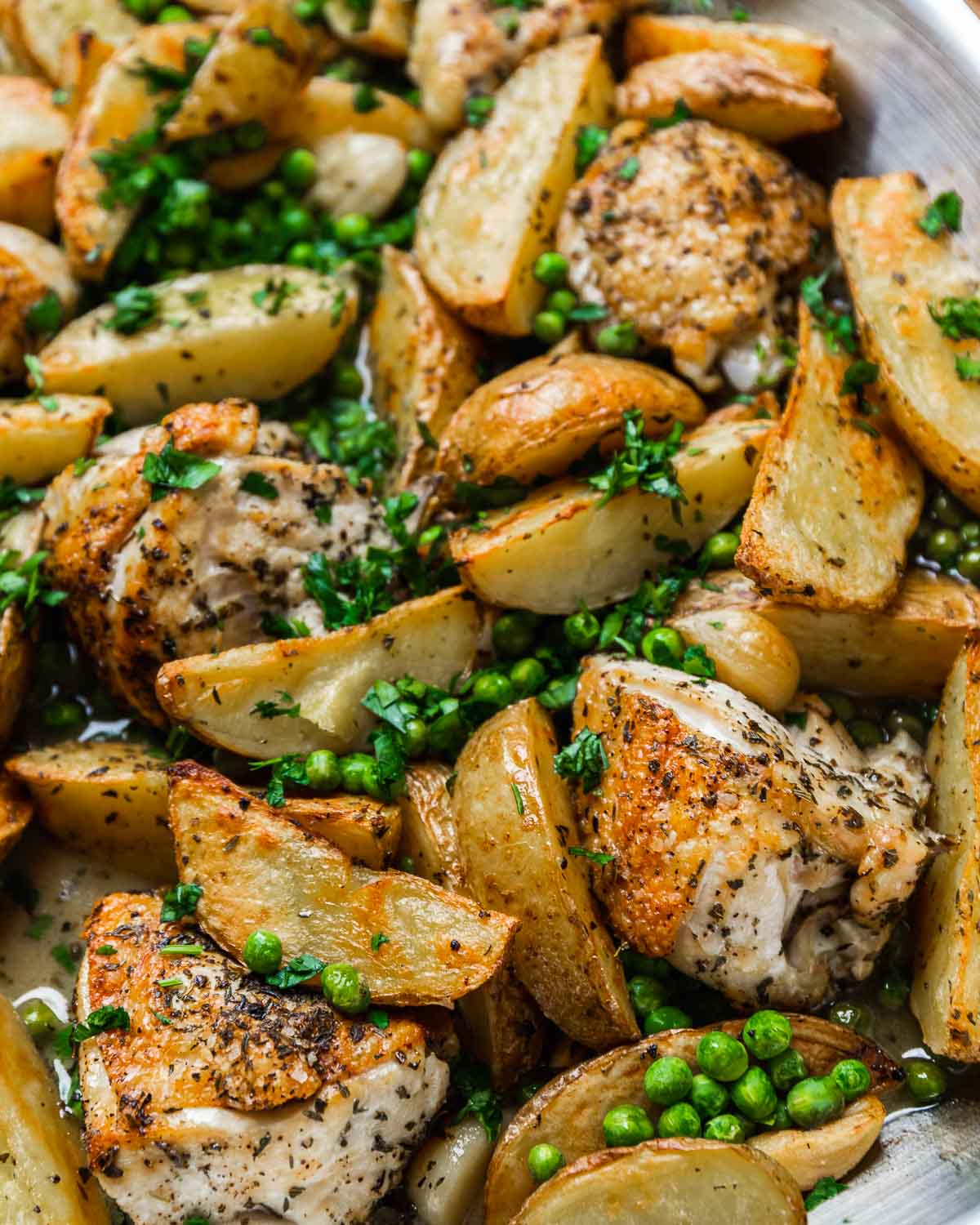 Chicken vesuvio with whole chicken pieces, peas, and parsley.