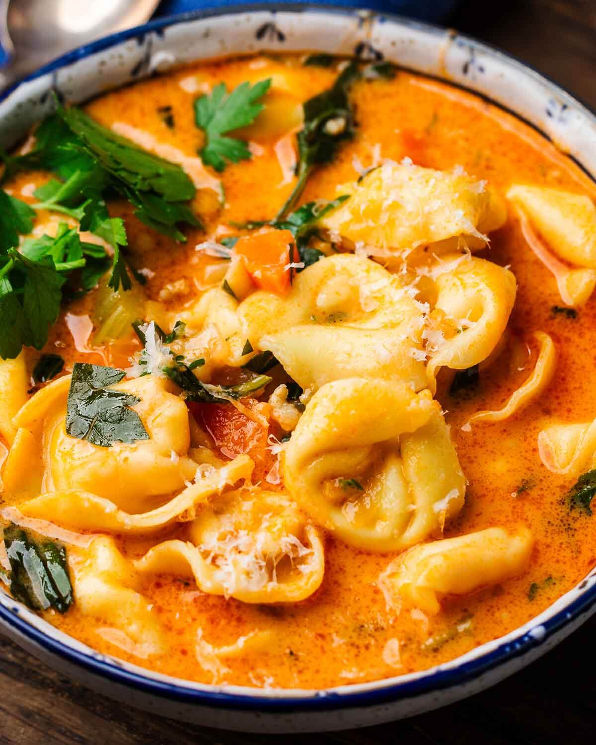 White bowl with creamy sausage tortellini soup.