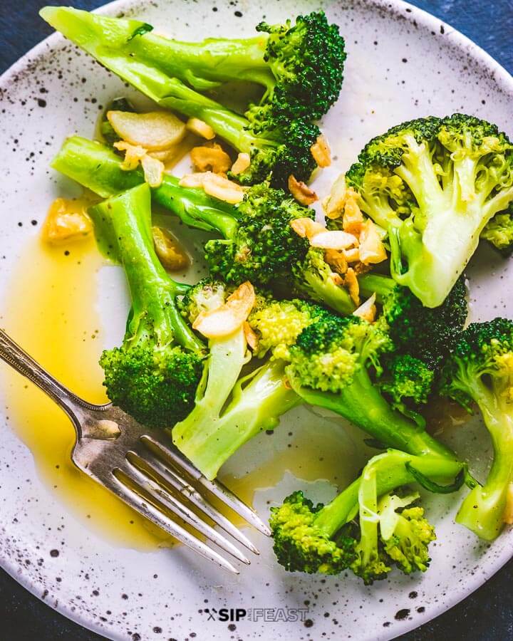 Italian broccoli on white plate with fork.