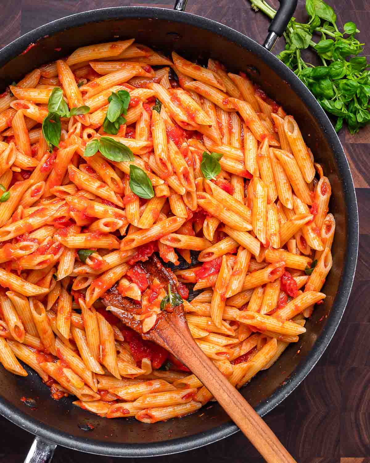 Penne with marinara sauce in black pan.