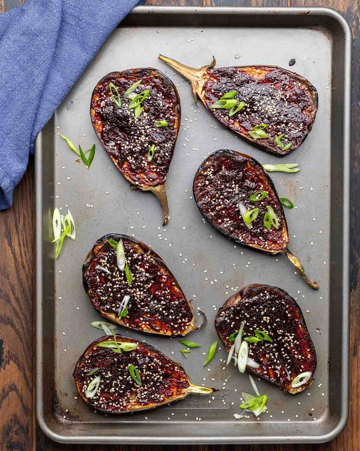 Overhead shot of miso eggplant on grey sheet pan.