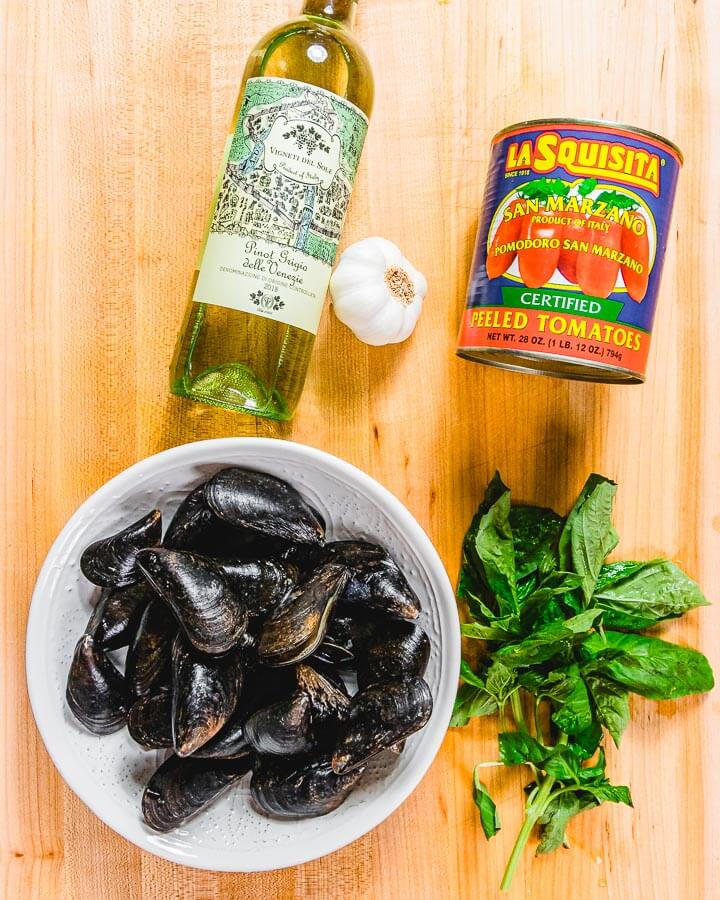 Ingredients shown: white wine, one can plum tomatoes, garlic, mussels, and basil.