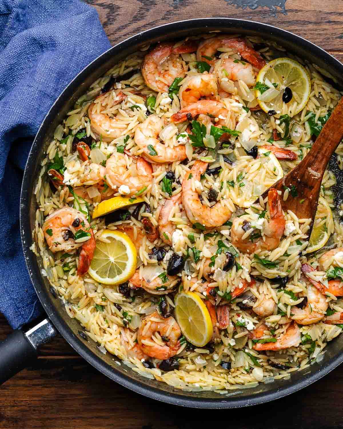 Large pan with orzo and shrimp with feta and black olives.