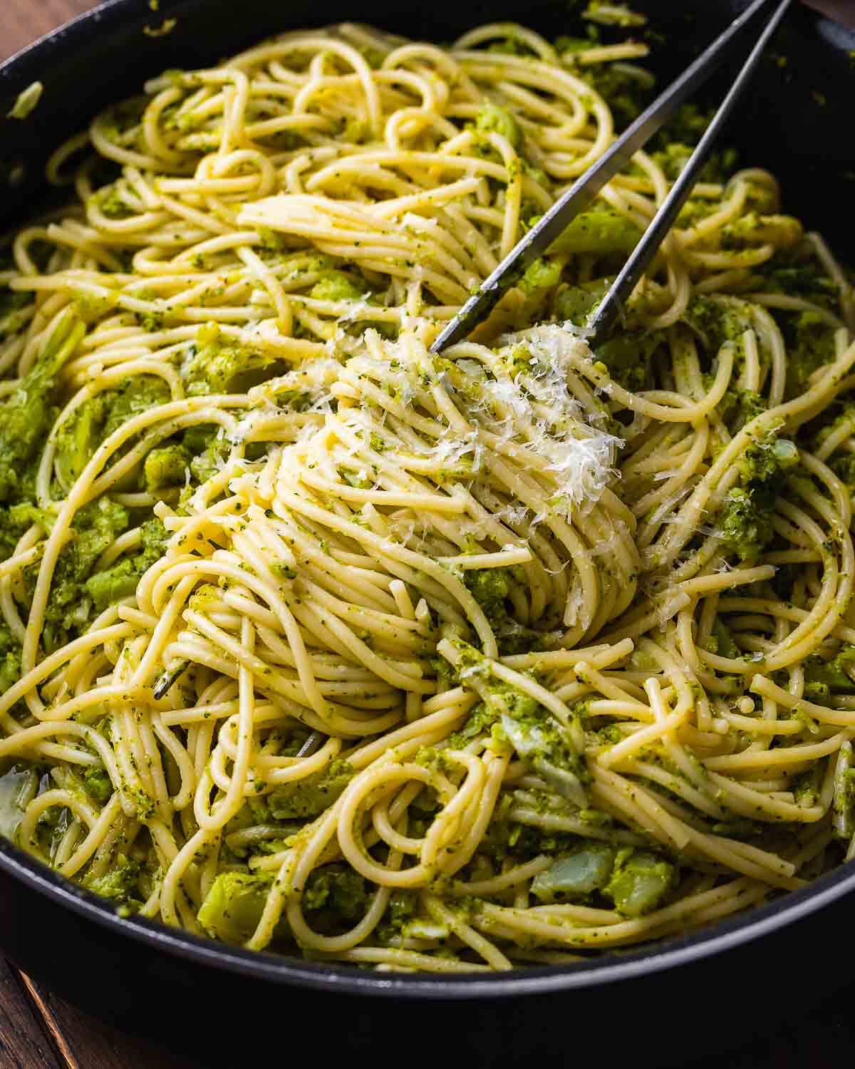 Large black pan with spaghetti and broccoli.