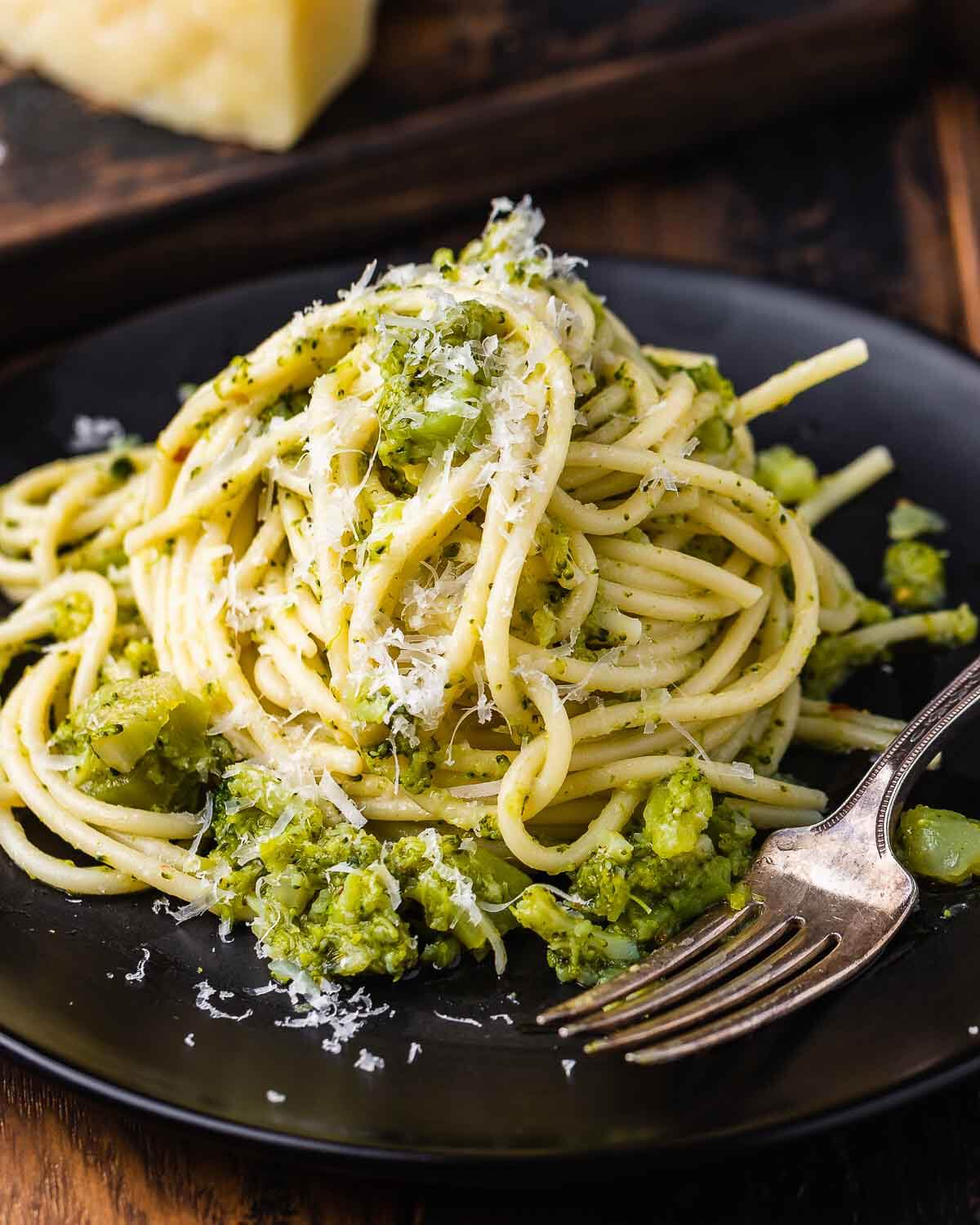 Black plate with pasta con broccoli.