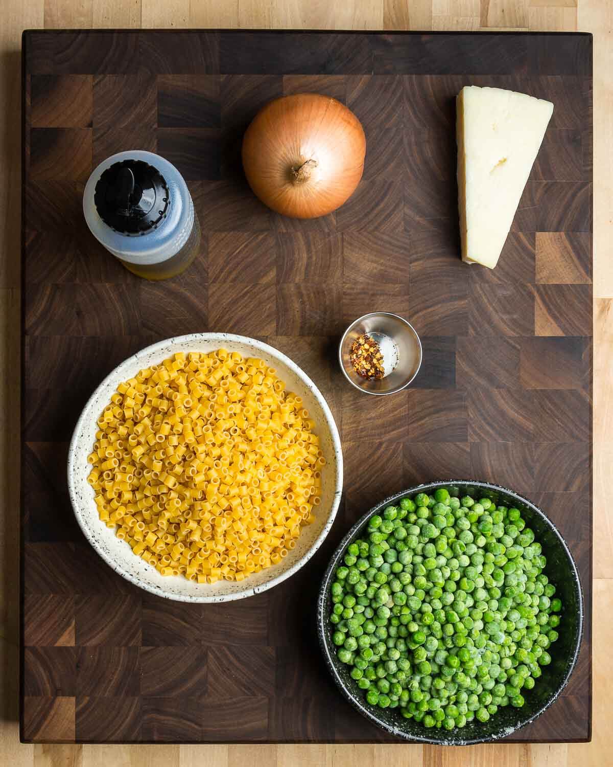 Ingredients shown: olive oil, onion, Pecorino Romano, ditalini pasta, hot red pepper flakes, and frozen peas.