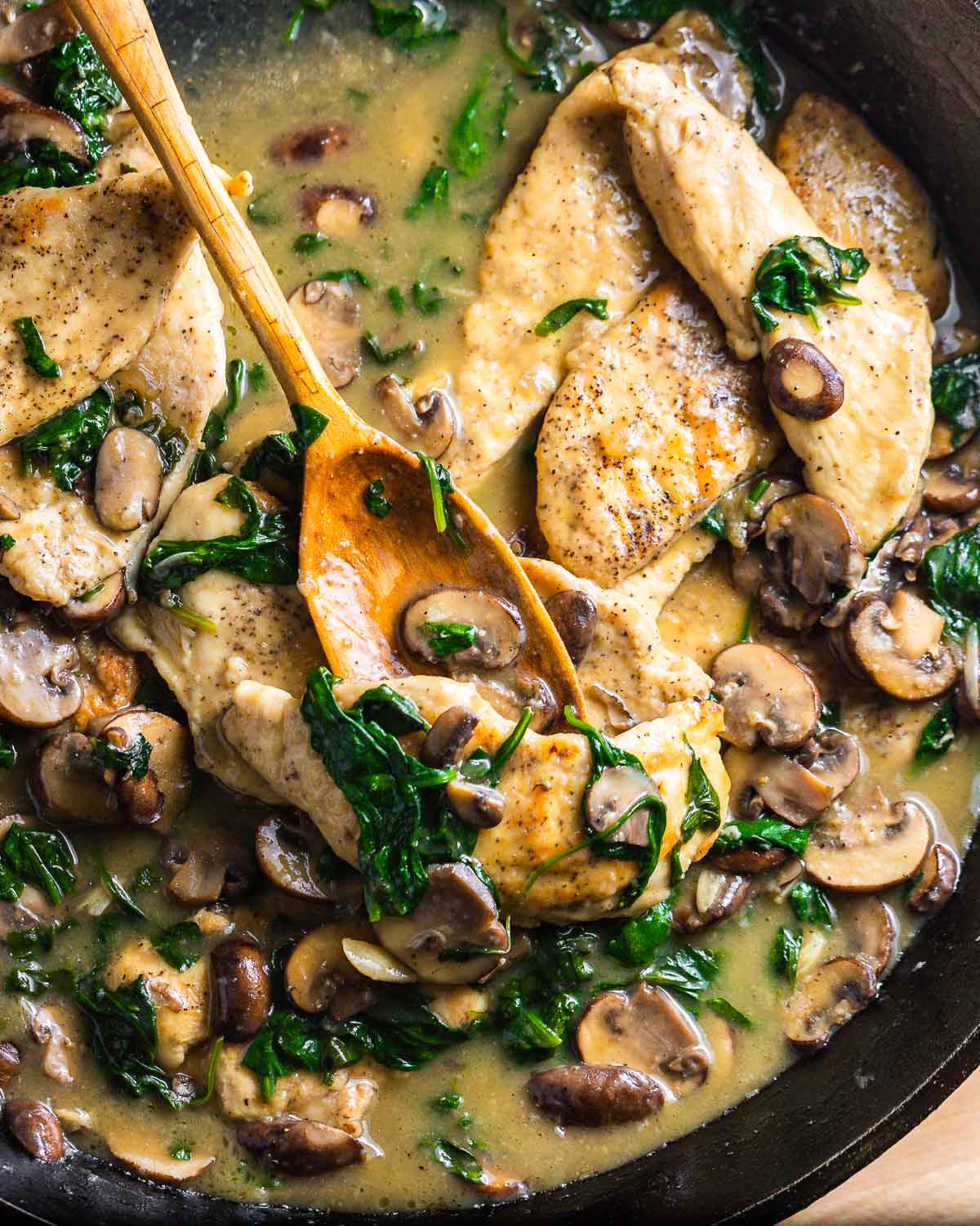 Spinach mushroom chicken in cast iron pan.