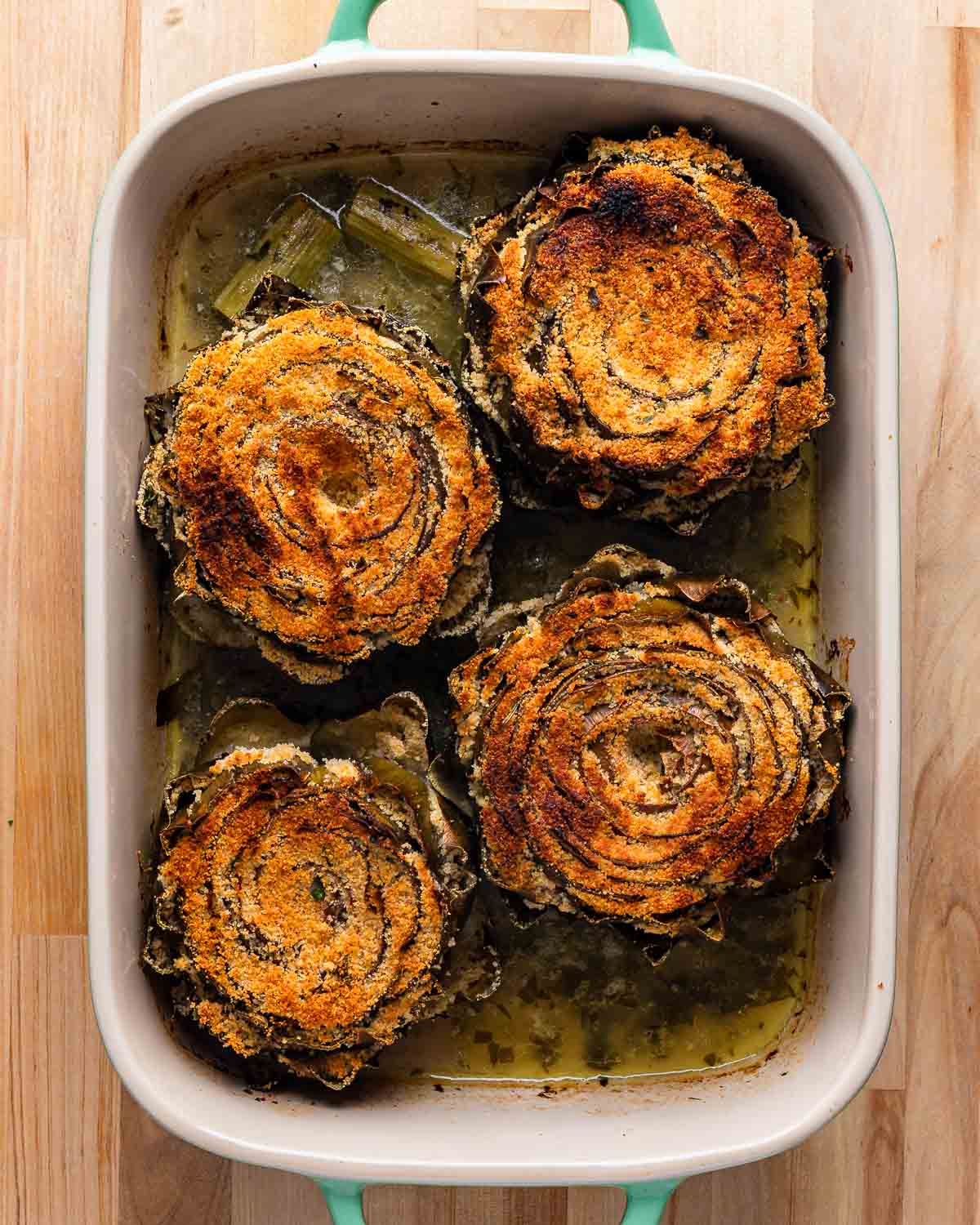 Overhead shot of baked stuffed artichokes.