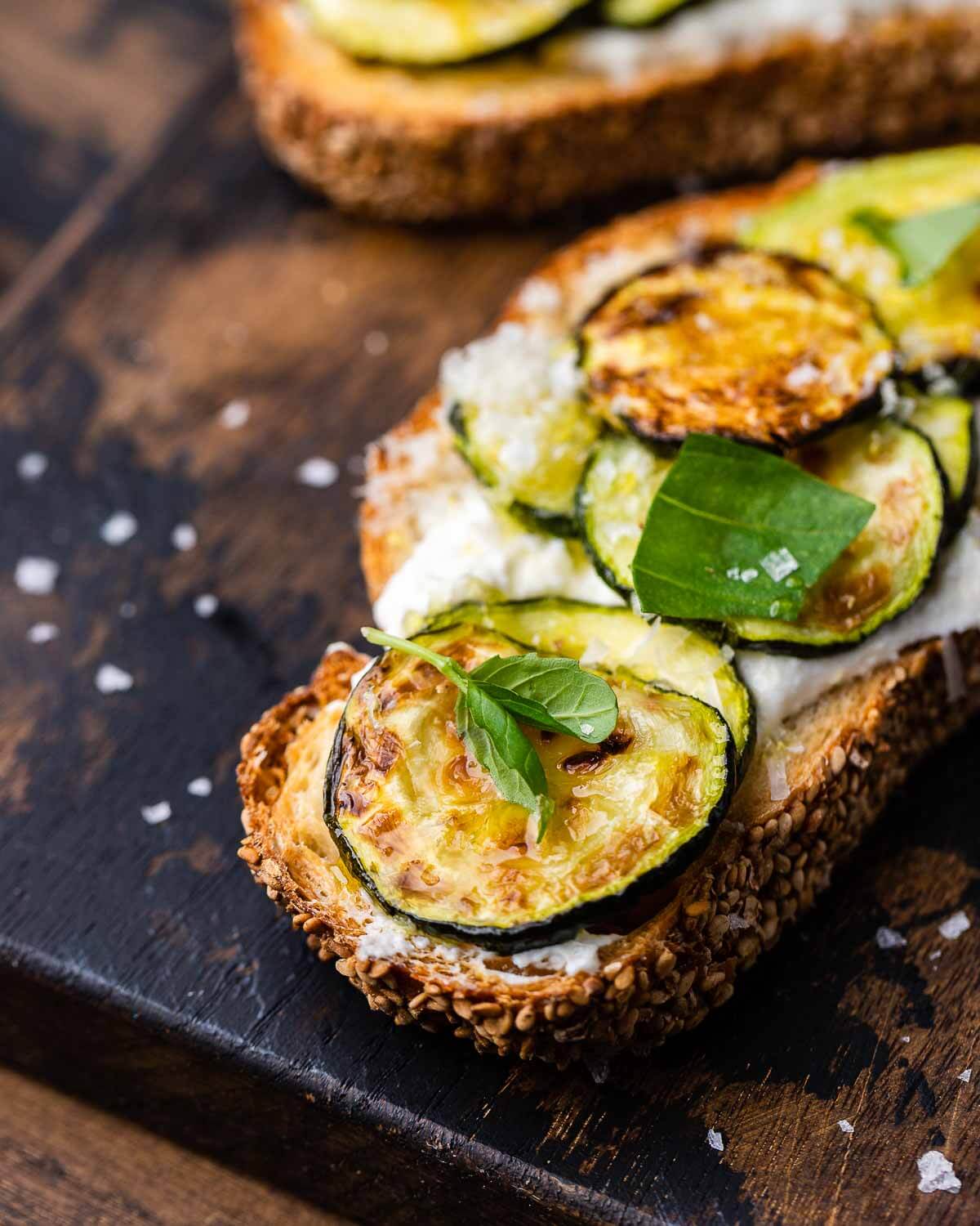 Closeup shot of zucchini bruschetta on wooden board.